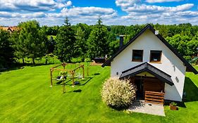 Domek z kominkiem nad jeziorem z jacuzzi ogrodowym